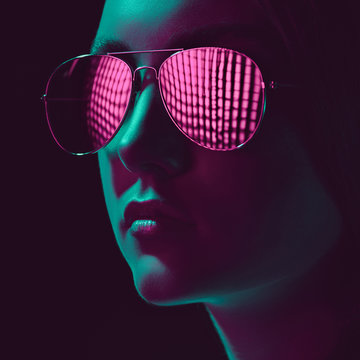 headshot of stylish young woman in sunglasses with pink lens