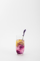 homemade summertime lemonade with lavender and lemon pieces in glass isolated on white