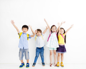 Group of happy smiling kids raise hands