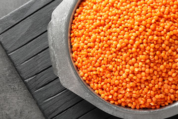 Plate with red lentils on wooden board
