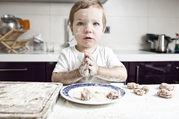 Baby boy kneading meatballs