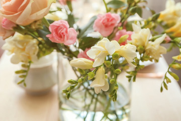 Beautiful bouquet of fresh freesia in vase on table