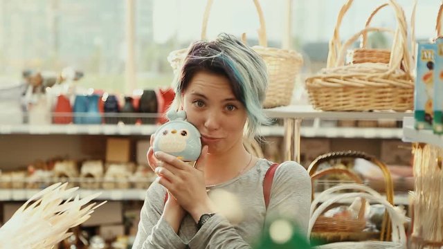 Beautiful girl holding a toy in the store. He laughs and fools around. Good mood. Unusual appe appearance