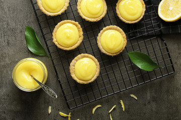 Composition with tasty cookies, lemon curd and cooling rack on table