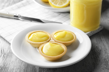 Plate with tasty lemon cookies on wooden table