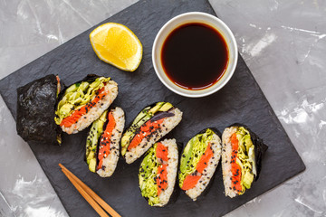 Healthy Japanese onigirazu with fish, brown rice and vegetables.