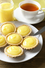 Plate with delicious lemon cookies on wooden table