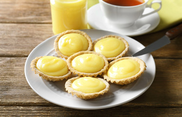 Plate with delicious lemon cookies on wooden table