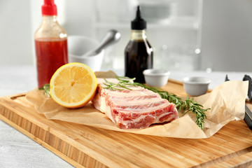 Raw ribs with ingredients on wooden board