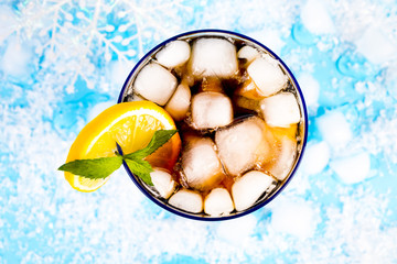 summer drink with ice and lemon on blue background