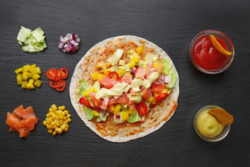 Ingredients for fish tacos on dark background