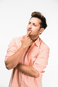 Portrait Of A Good Looking Confused Indian Man Or Handsome Indian Man In Thinking Pose, Standing Isolated Over White Background
