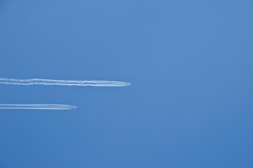 Two planes flying in parallel, leaving behind a white trail.