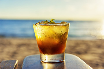 The frozen glass of Mojito cocktail on the Ibiza beach party at sunset