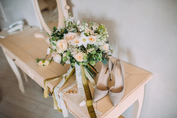 beautiful wedding bouquet with white, red and purple flowers standing with bride's shoes