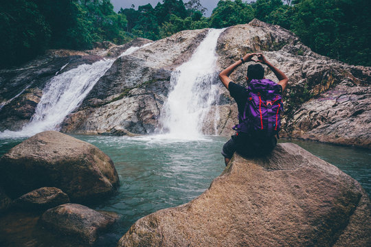 Man sitting in front waterfall in pahang,malaysia