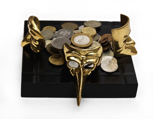 Beautiful carnival masks  on a black countertop with coins