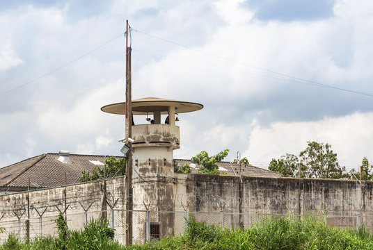 old prison guard tower or watchtower with security systems barbed wire fence around the wall jail