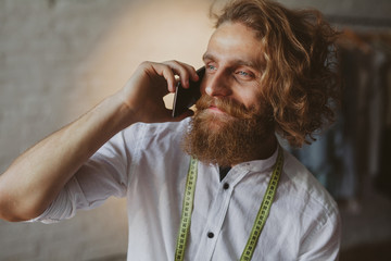 Bearded man holding phone standing