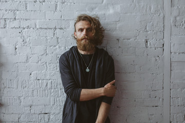 Blonde bearded curly haired man posing