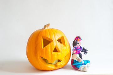 Curved pumpkin for Halloween and Mexican Doll wearing multicolored costume.