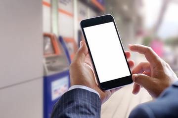 Closeup of male hands using smart phone for e-banking  with ATM, bank machine background.