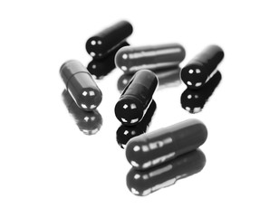 Black pill capsules isolated on white background