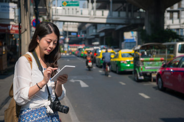 Chinese woman using tablet while walking