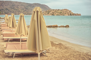 Deserted beach with sun umbrellas and sun beds