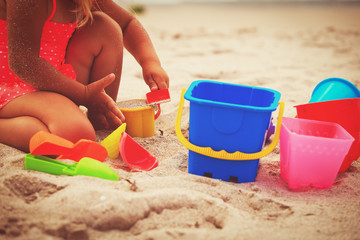 hands of little girl play with sand on beach