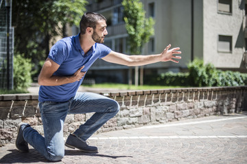 giovane chiede aiuto in un parco a causa di dolore al cuore durante infarto