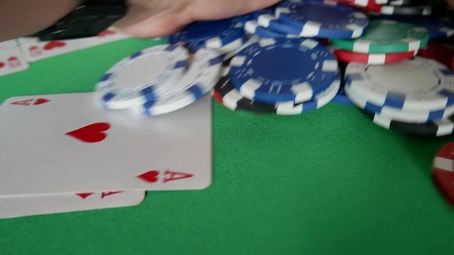 Poker Player Moves Chips on Table at Casino. Casino Chips And Double Aces. Winner In Poker. Poker Player Going All-in