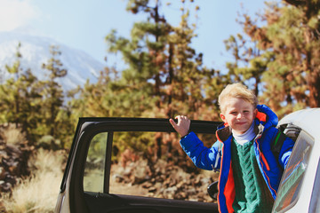 Naklejka premium happy little boy loves to travel by car in nature