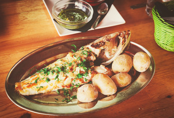 Grilled fish and potato served in restaurant