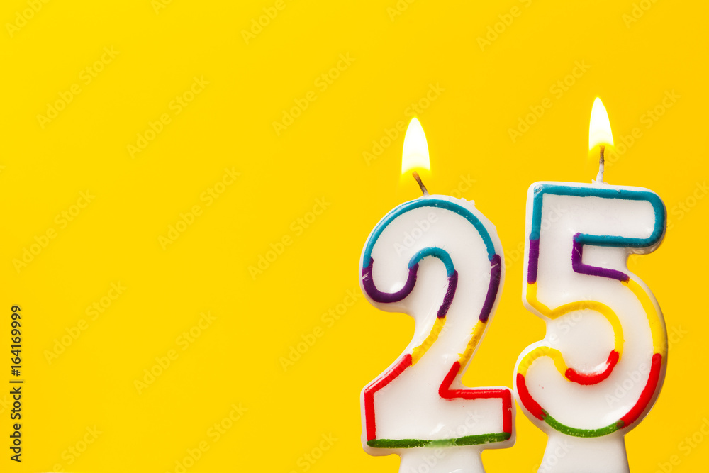 Wall mural number 25 birthday celebration candle against a bright yellow background