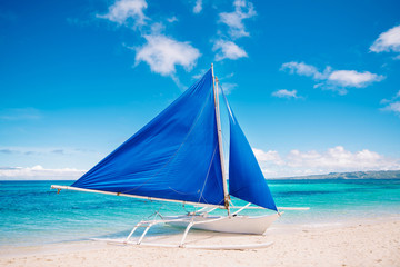 Ready to travel by blue sail boat. Tropical turquois sea on the background.