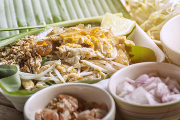 Close up Pad-Thai and garnish  Food of Thailand for Take home Arrange on a wooden table.
