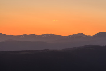 Orange sunrise with mountains. Atmospheric phenomena concept
