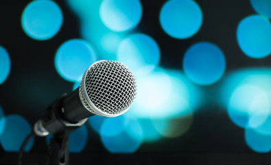 Fototapeta na wymiar Microphone on abstract blurred of speech in seminar room or speaking conference hall light, Event concert bokeh background
