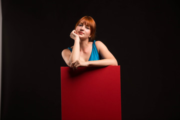 Young pensive woman portrait of a confident businesswoman showing presentation, pointing placard background. Ideal for banners, registration forms, presentation, landings, presenting concept.