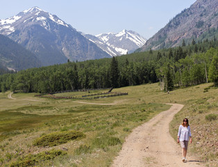 Fototapeta na wymiar A Woman Walks a Road on the Alpine Loop Backcountry Byway