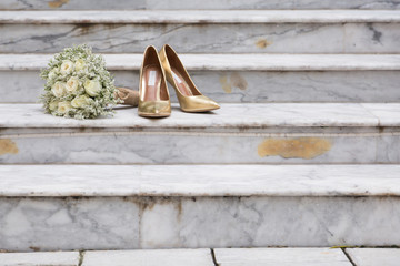 White Rose Bouquet and Gold Wedding Shoes on Marble Steps