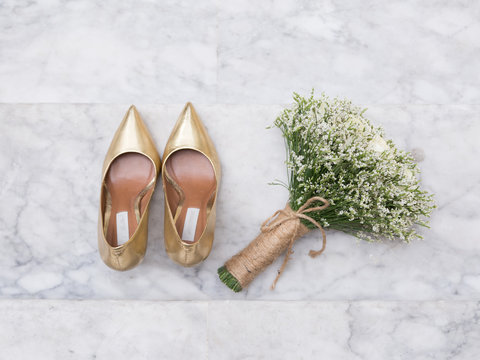 White Rose Bouquet and Gold Wedding Shoes on Marble Steps