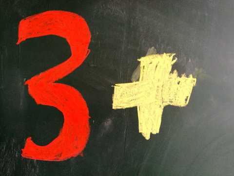 Die Zahl Drei in Rot mit einem Pluszeichen auf einer Kreidetafel im Unterricht f&uuml;r Mathematik der Grundschule in Helpup bei Oerlinghausen und Bielefeld im Teutoburger Wald in Ostwestfalen-Lippr