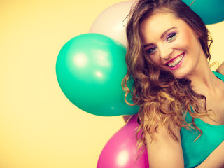 Woman holding bunch of colorful balloons