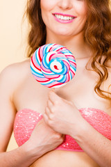 Woman holding colorful lollipop candy in hand.