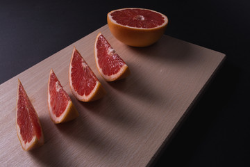 Slice of fresh grapefruit on wooden board