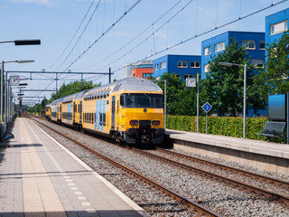 A yellow train is leaving a station.