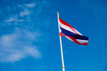 Image of waving Thai flag of Thailand with blue sky background.