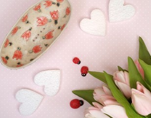 Delicate maiden Composition with hearts and a bouquet of tulips on a pink abstract background